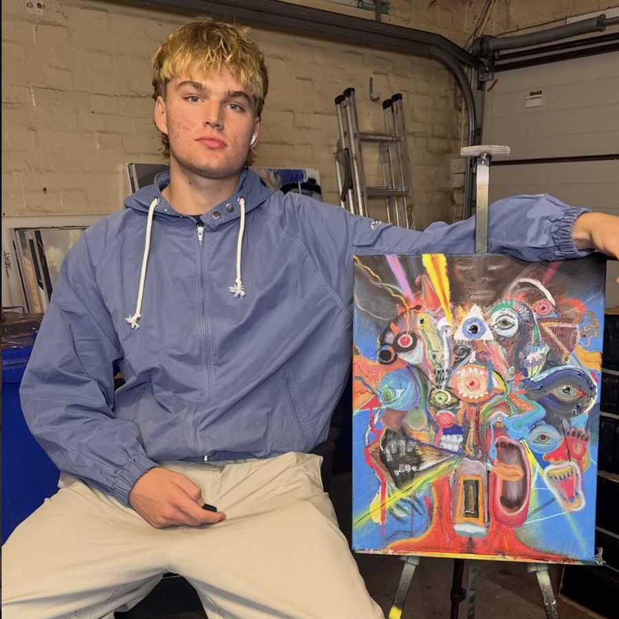 Ben Key sitting beside his painting for the Run With Me cover